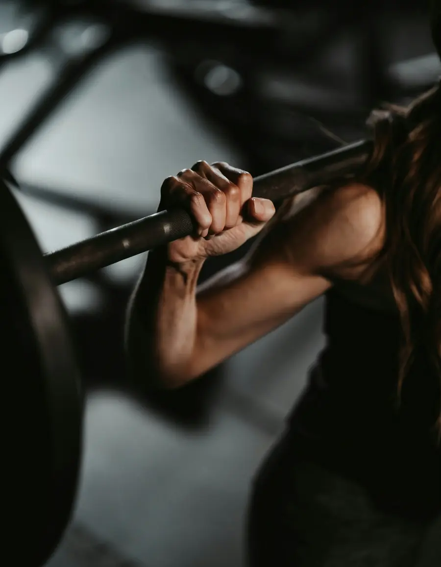 glockna, dein Wellnesshotel an der Großglockner Hochalpenstraße Frau hält Langhantelstange beim Krafttraining im Fitnessstudio
