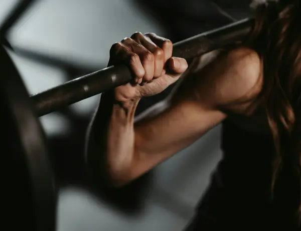 glockna, dein Wellnesshotel an der Großglockner Hochalpenstraße Frau hält Langhantelstange beim Krafttraining im Fitnessstudio