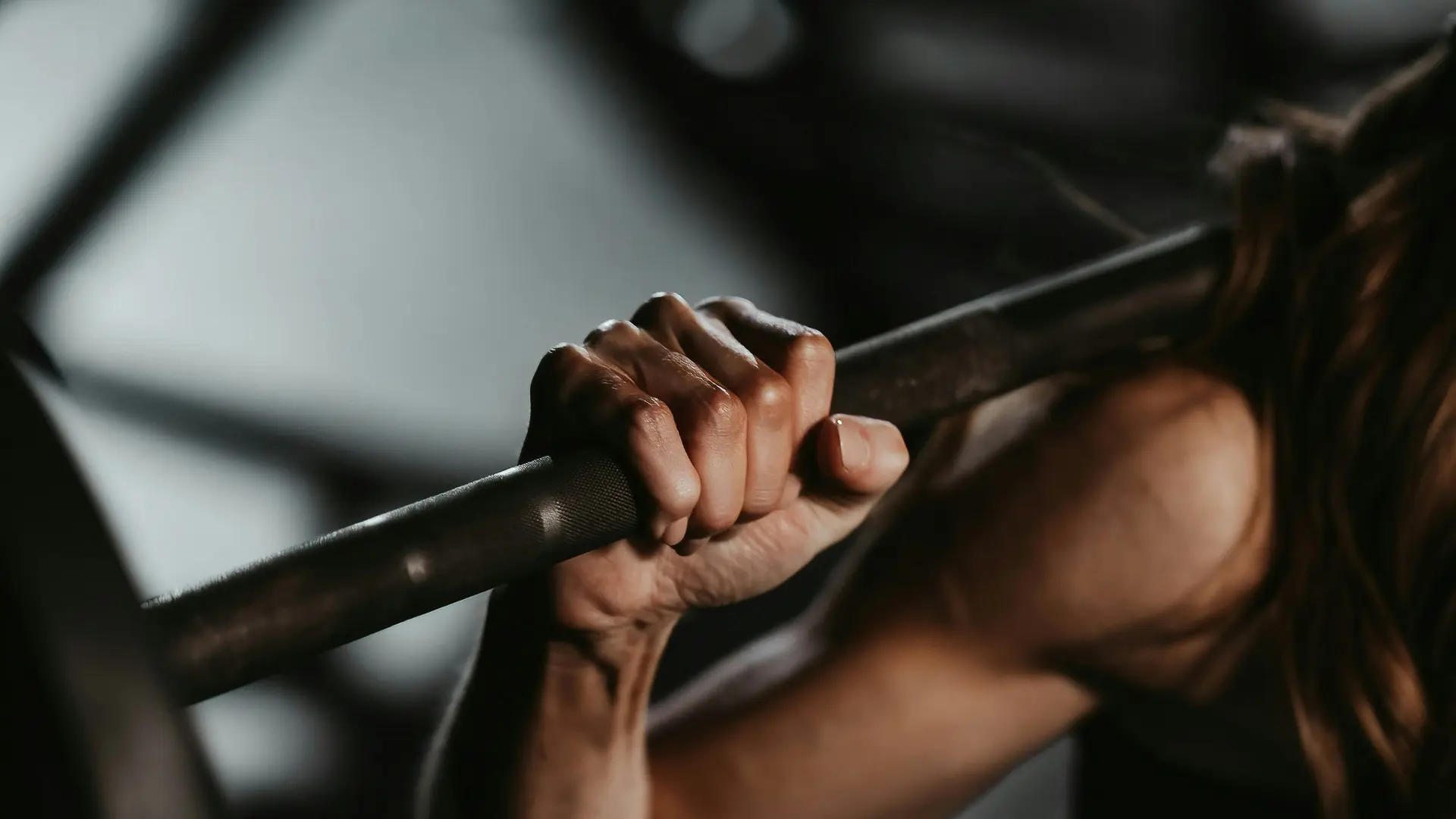 glockna: your sport hotel in the Salzburg region Woman gripping barbell during strength training in gym