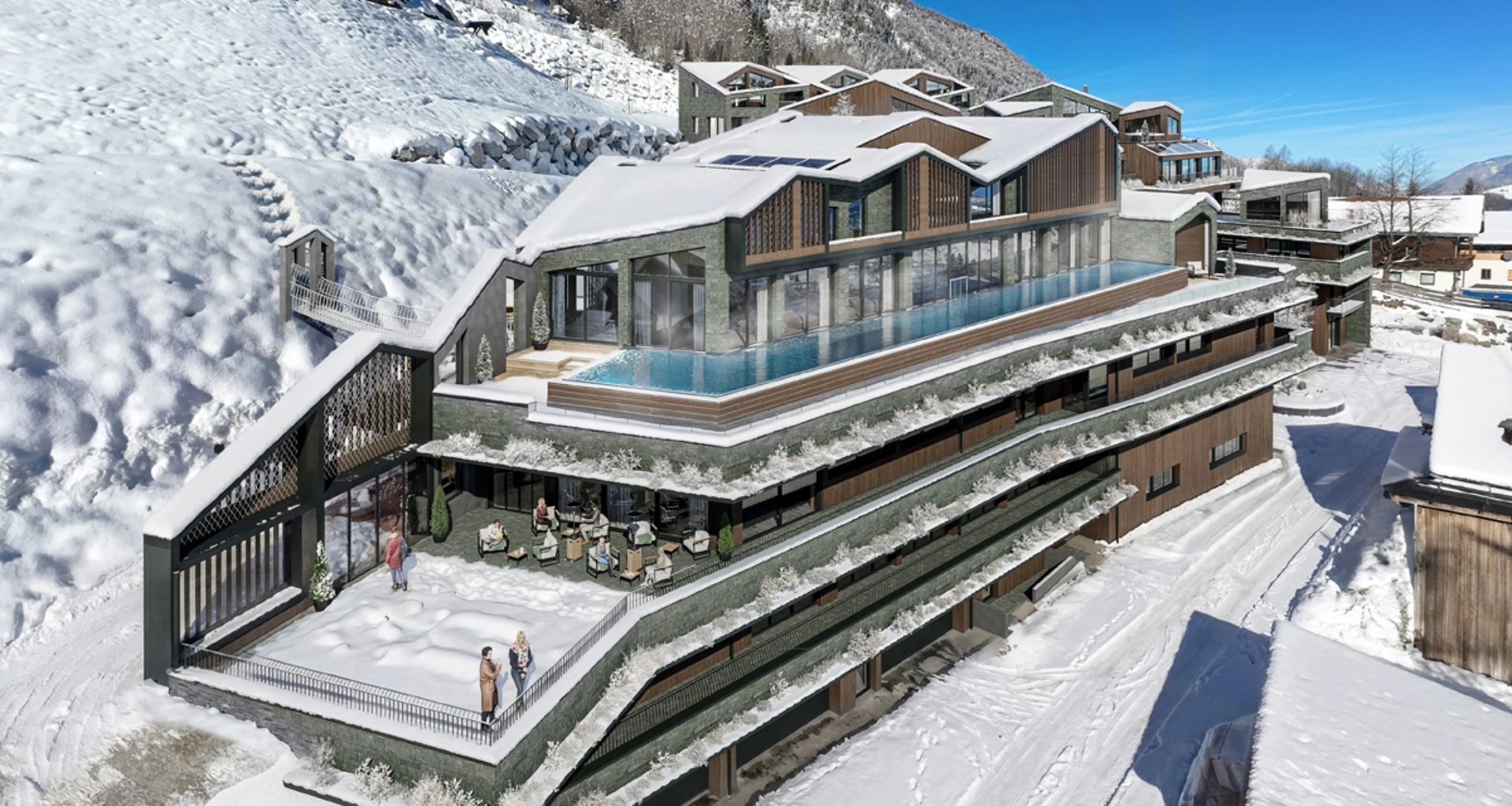 Modernes Hotel mit Außenpool und Terrasse im verschneiten Berggebiet