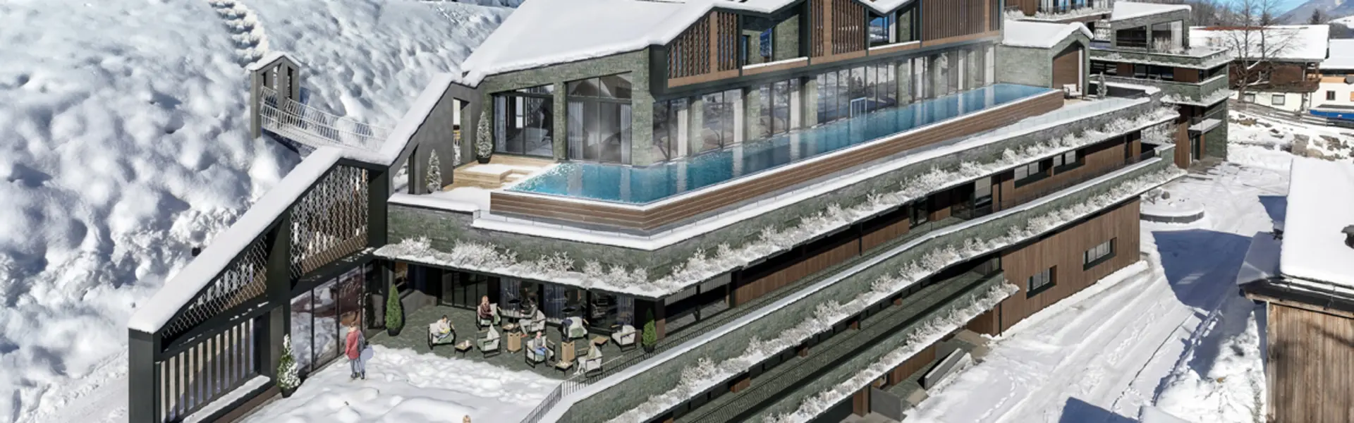 Modernes Hotel mit Außenpool und Terrasse im verschneiten Berggebiet