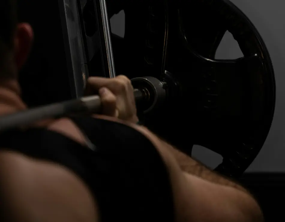 glockna: your sport hotel in the Salzburg region Man lifting barbell with weight plate in gym