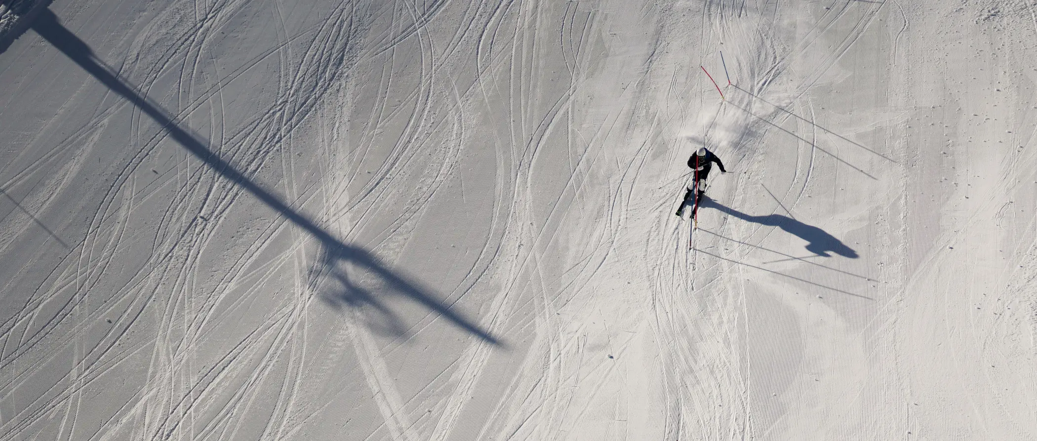 Der Aktivurlaub im SalzburgerLand mit Beschleuniger Skifahrer auf schneebedeckter Piste mit Spuren und Schatten von Skilift