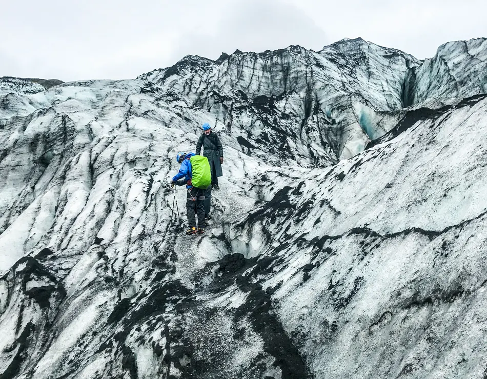 Bergsteigen mit Blick auf den Großglockner Zwei Wanderer auf einem schneebedeckten Gletscher mit felsiger Landschaft