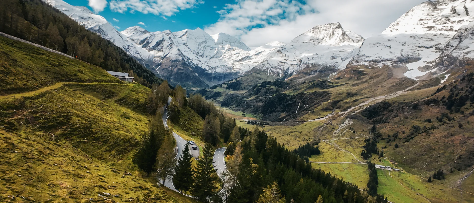 Spektakuläre Aussicht auf die Serpentinen der Großglockner Hochalpenstraße in Fusch, nahe dem Designer Motel Glockna, mit schneebedeckten Alpengipfeln.