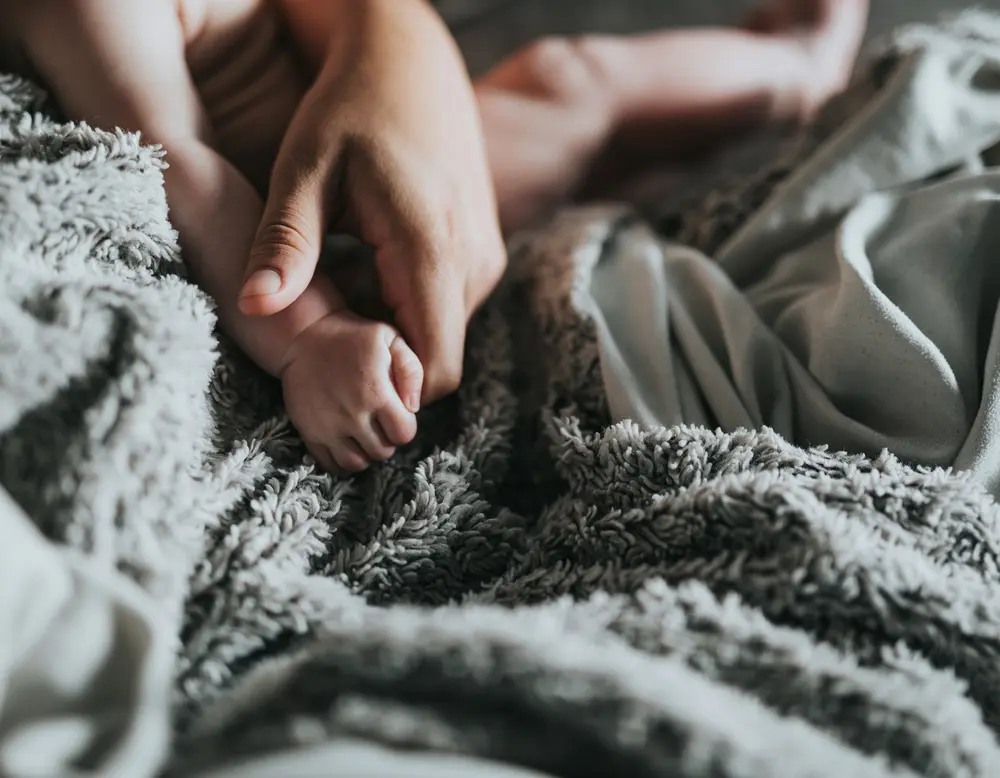 Frequently asked questions about Designer Motel glockna Adult hand holding baby's hand on soft gray blanket