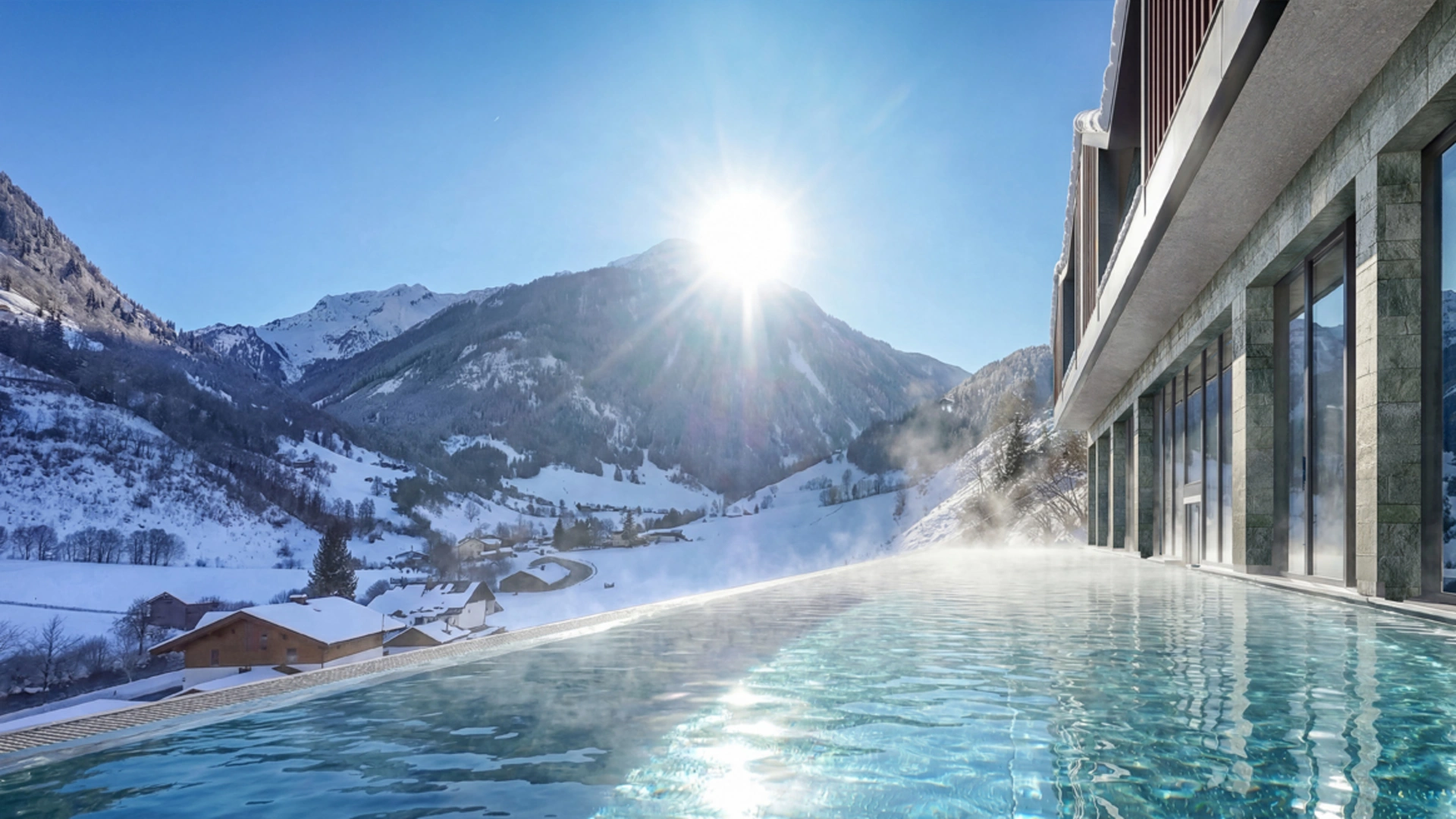 The loveliest infinity pool in the Salzburg region – at glockna Infinity pool with mountain view and sunshine in snowy winter landscape