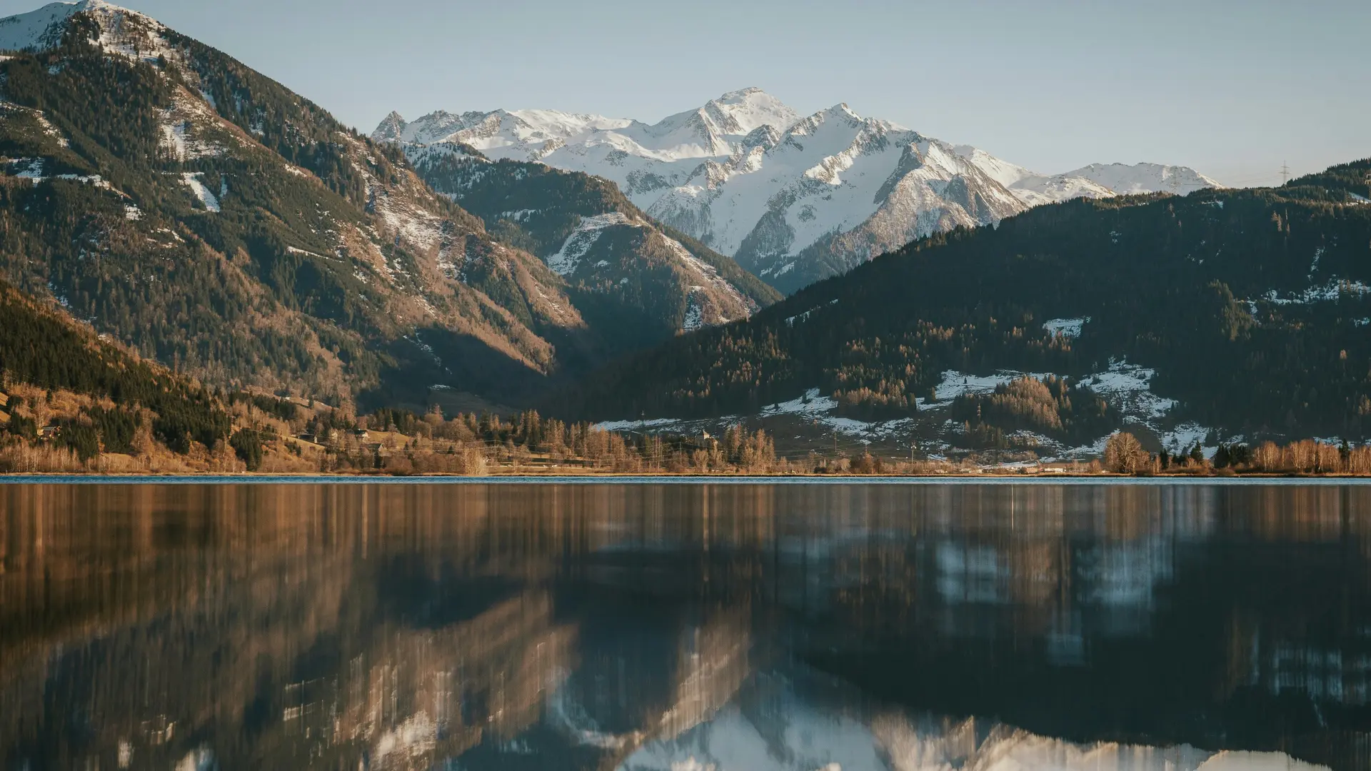 Keine Lust auf 08/15? Besuche unser Hotel unweit des Zeller Sees! Berglandschaft mit schneebedeckten Gipfeln und Spiegelung im ruhigen See