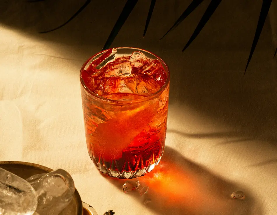 glockna bar – drinks & sundowners on the Grossglockner Road Glass of red drink with ice cubes on light cloth next to ice bucket and tongs