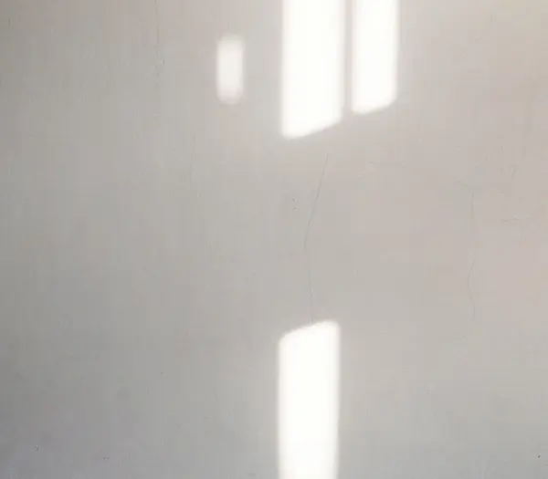 Übernachtung an der Großglockner Hochalpenstraße Lichtstrahlen fallen durch Fenster auf eine weiße Wand mit feinen Rissen