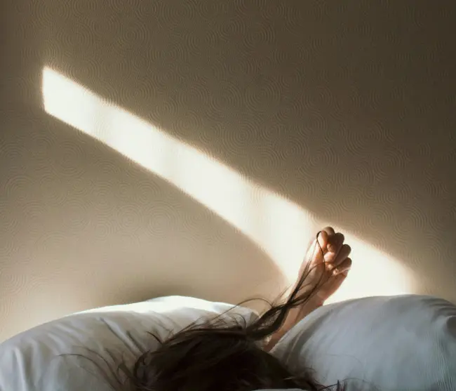 glockna in the press Person sleeping in bed with sunlight casting on the wall