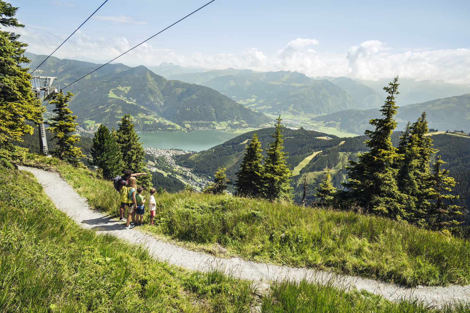 glockna, your hotel in Austria for a walking holiday Family hiking on mountain trail with lake and mountain view